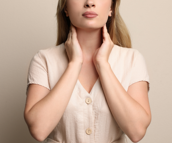 A woman feels her thyroid to check for thyroid disease.