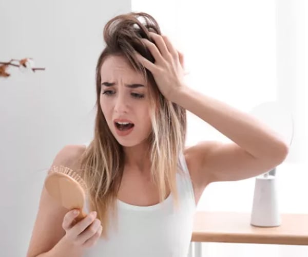 Women noticing hair being lost on brush