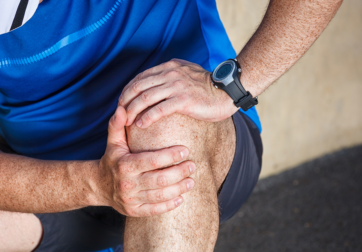 A man massages his knee as he tries to ease joint pain.