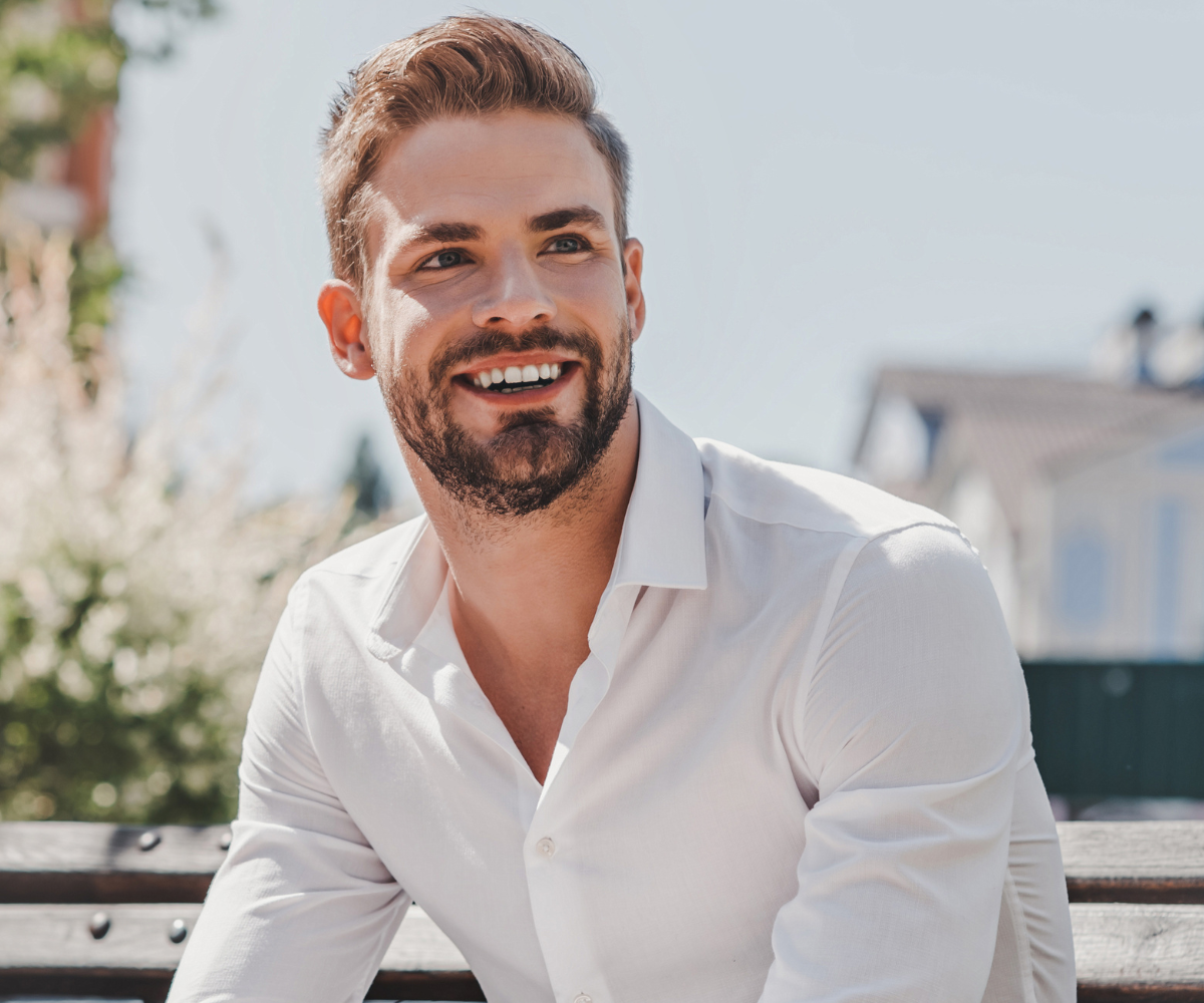 A handsome dark-haired man smiles as he looks to the right.