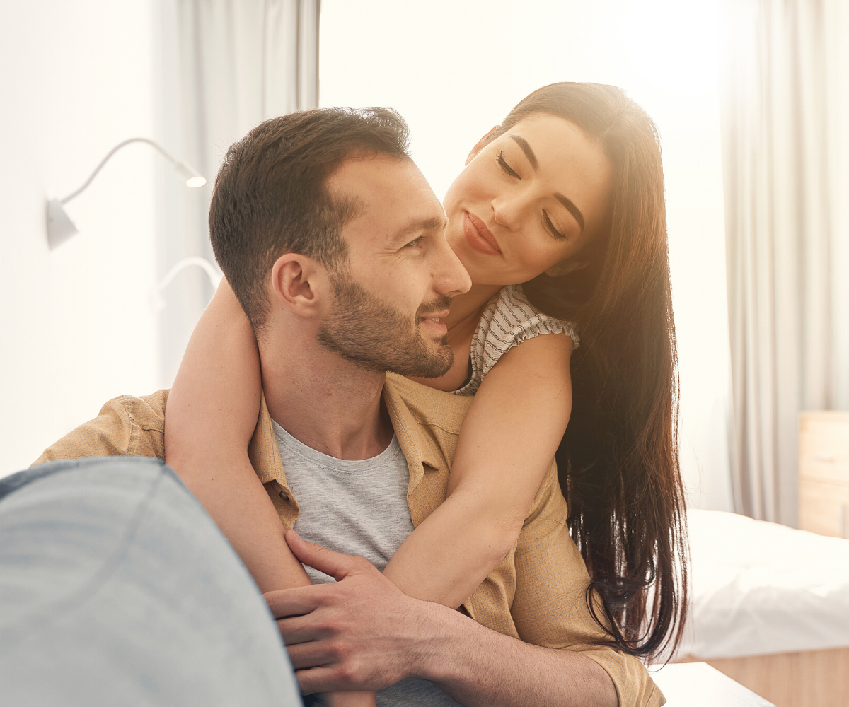 A man with a receding hairline smiles and laughs with his female partner.