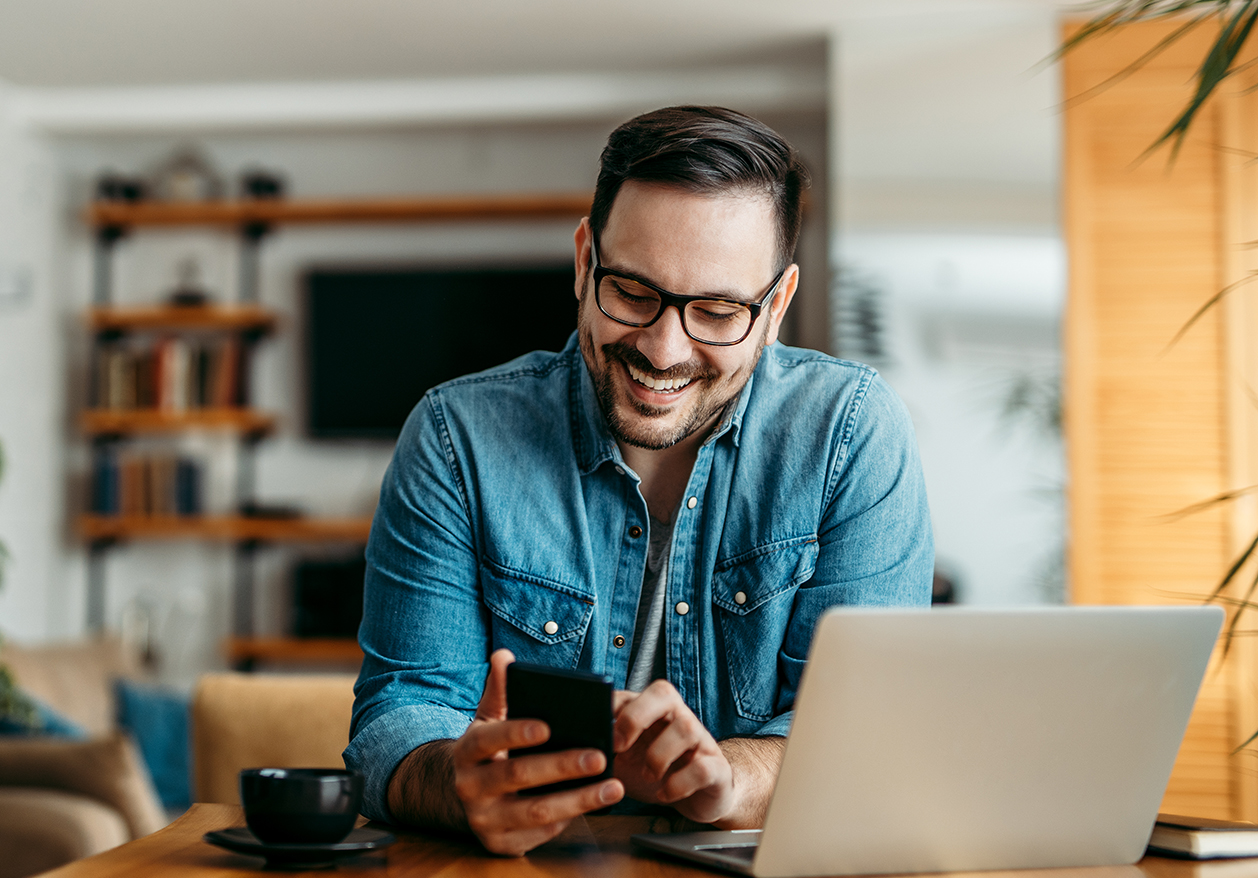 A man smiles at his smart phone as he taps the screen, showing his happiness with Defy Medical's advice only consults.