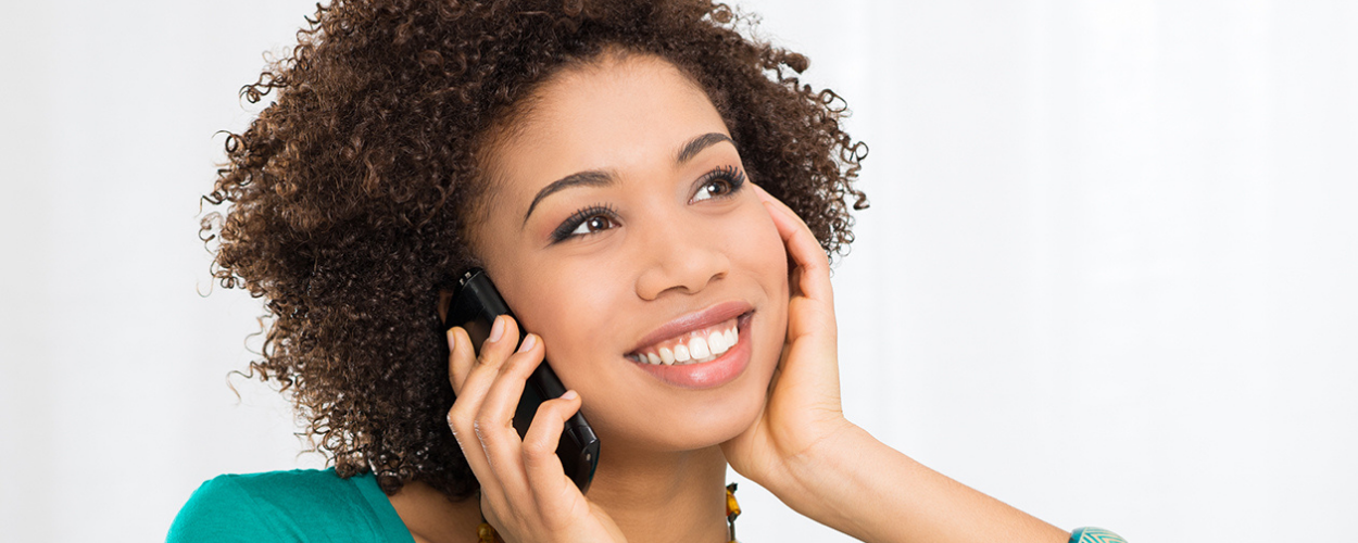 A woman books an IV therapy appointment on the phone.