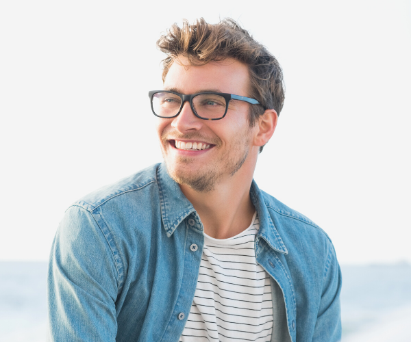 Man with glasses smiling.