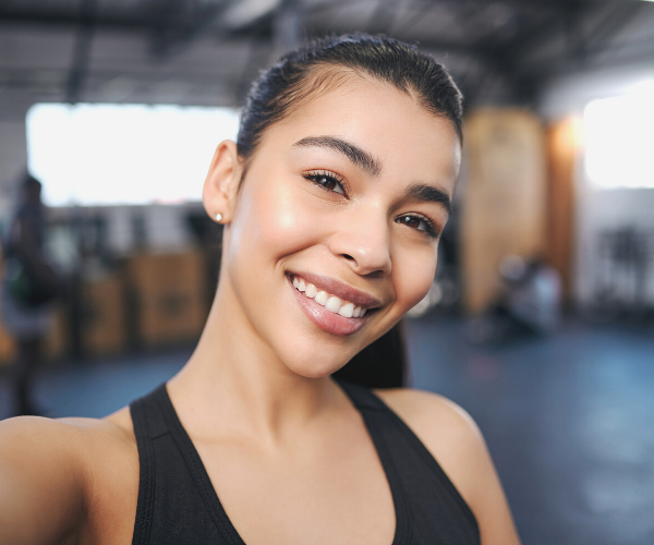 Young woman in a gym smiling for a selfie