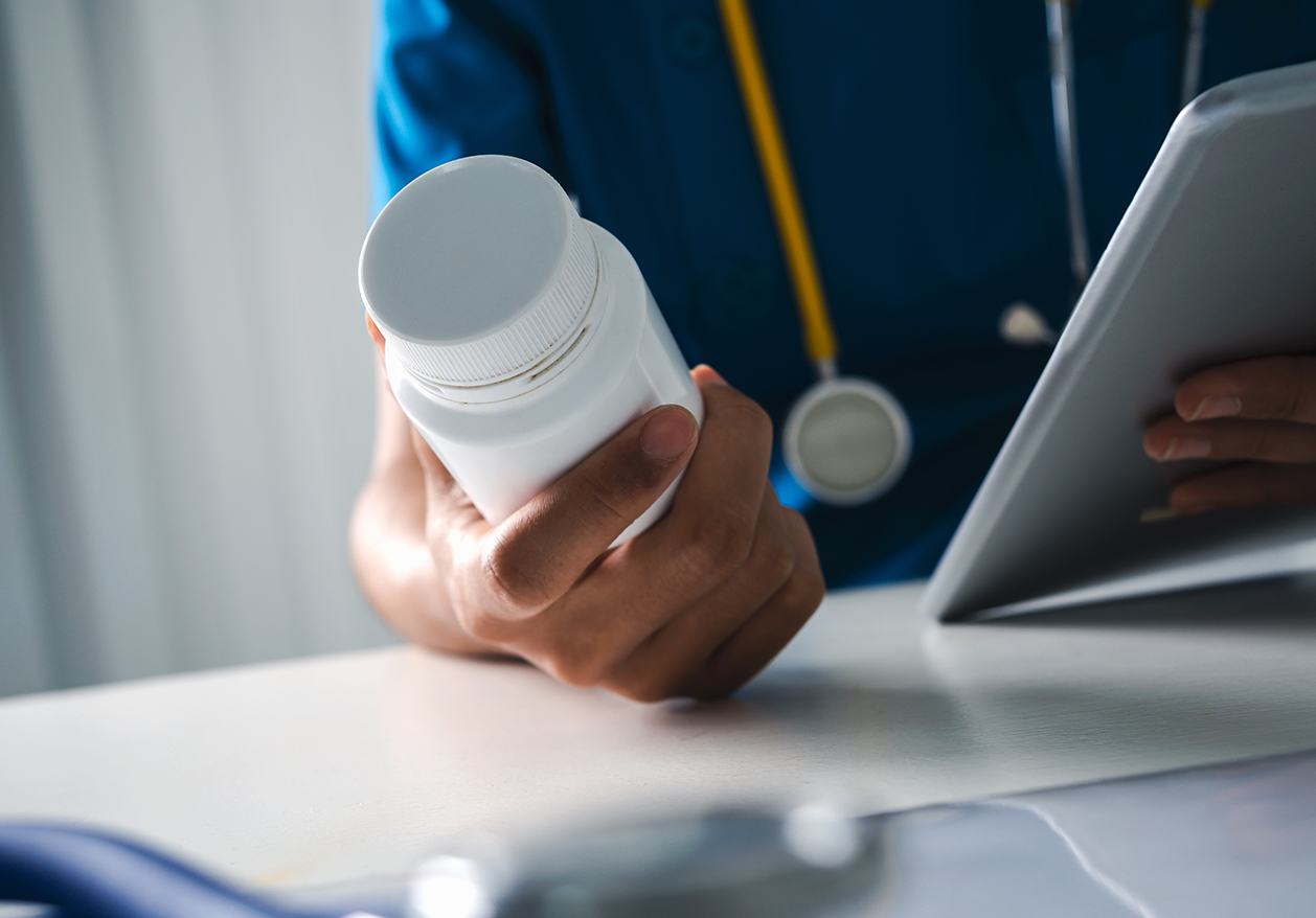 A Defy Medical vendor holds a prescription bottle and a tablet.