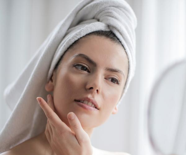 Woman with healthy skin applying wrinkle cream to face