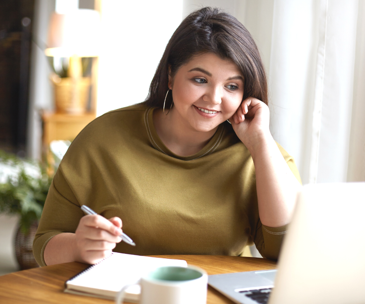 A plus-sized woman smiles as she researches the cost of Semaglutide online