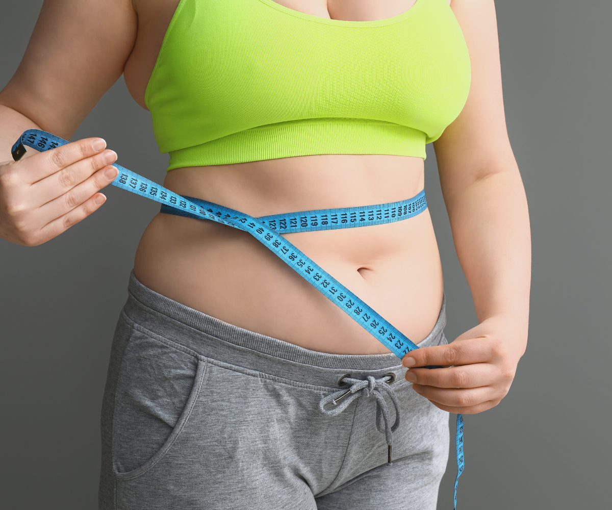 A woman takes her measurements to see if she's in a weight loss plateau.