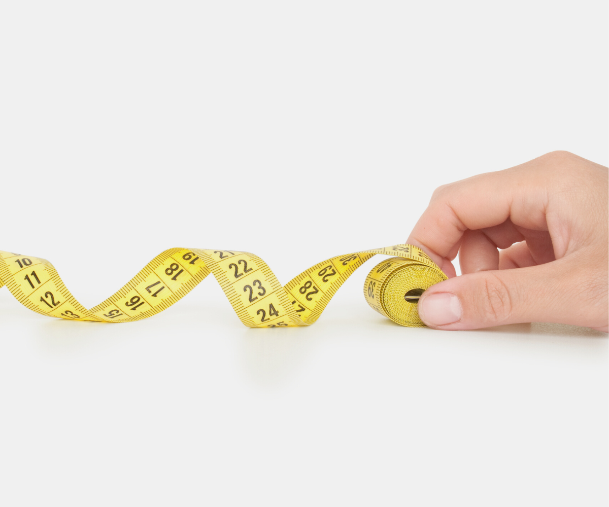 A man with a measuring tape measures his finger length