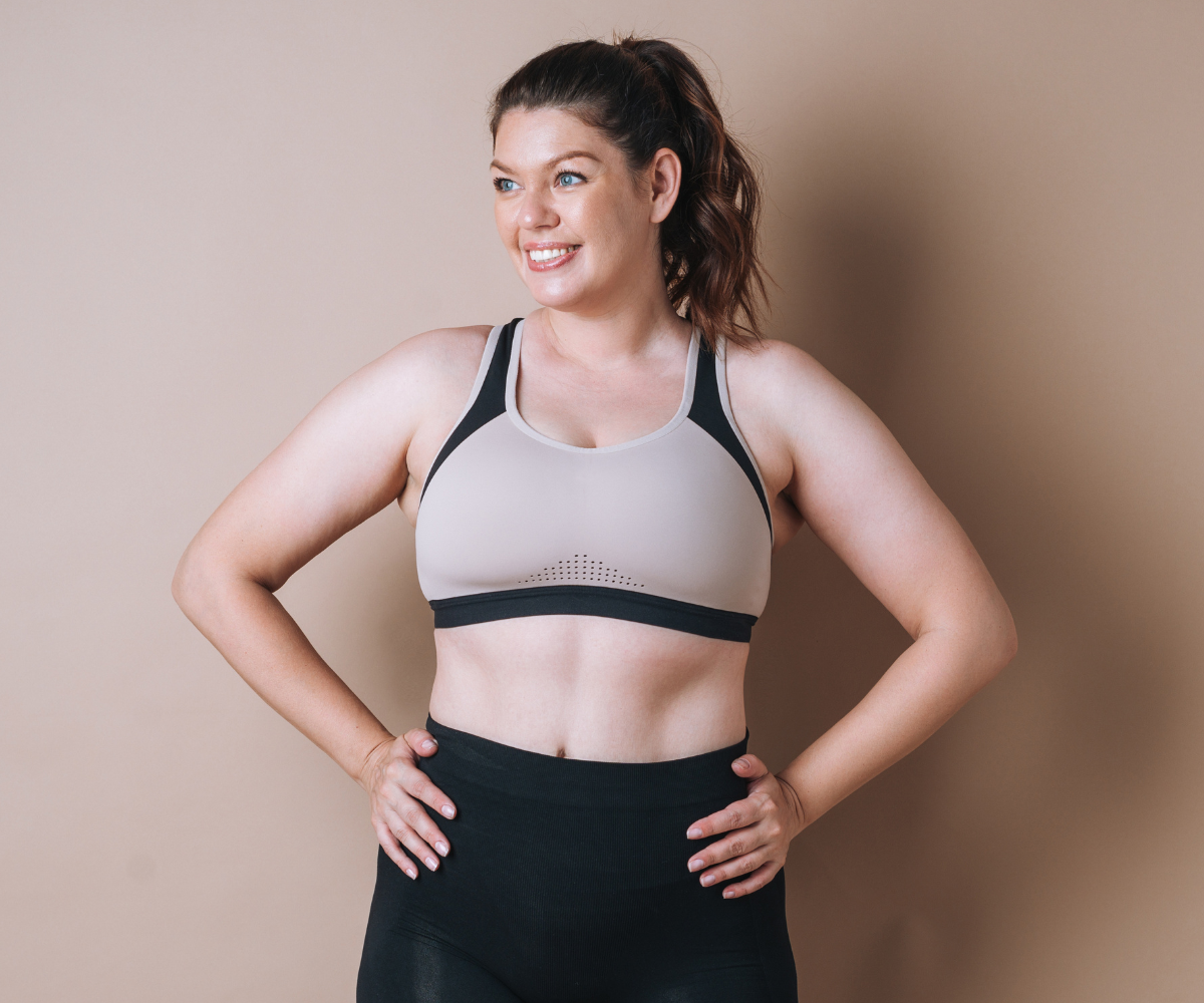 A woman smiles and poses with her hands on her hips as she shows off the results of choosing the best weight loss injection.